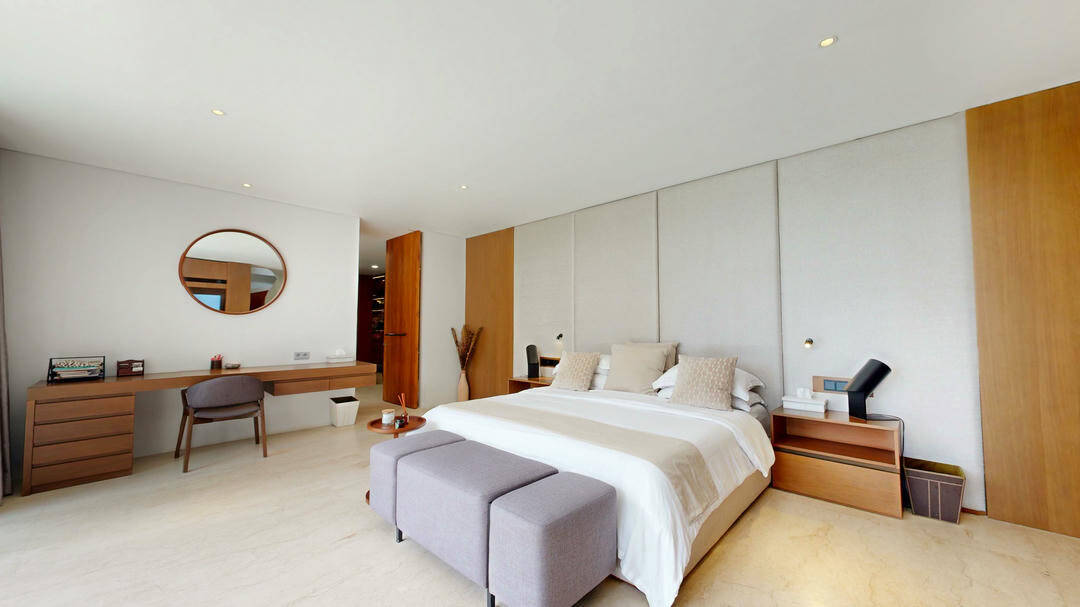 Modern bedroom with bed, desk, and decor.