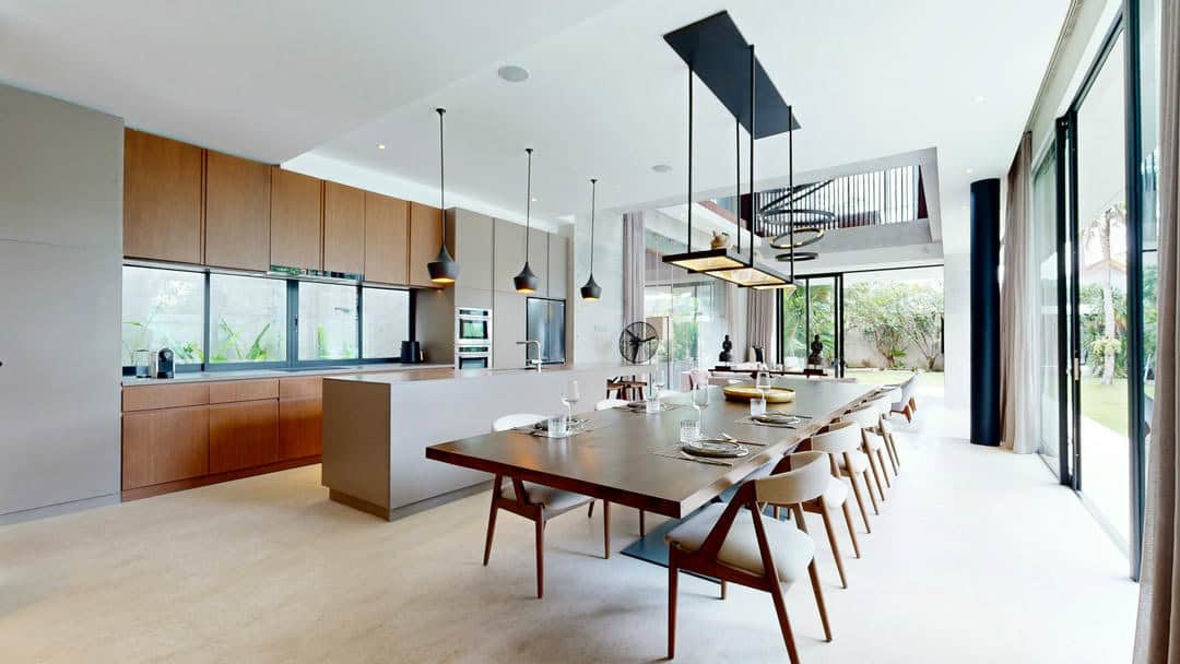 Modern kitchen with large dining table and windows.