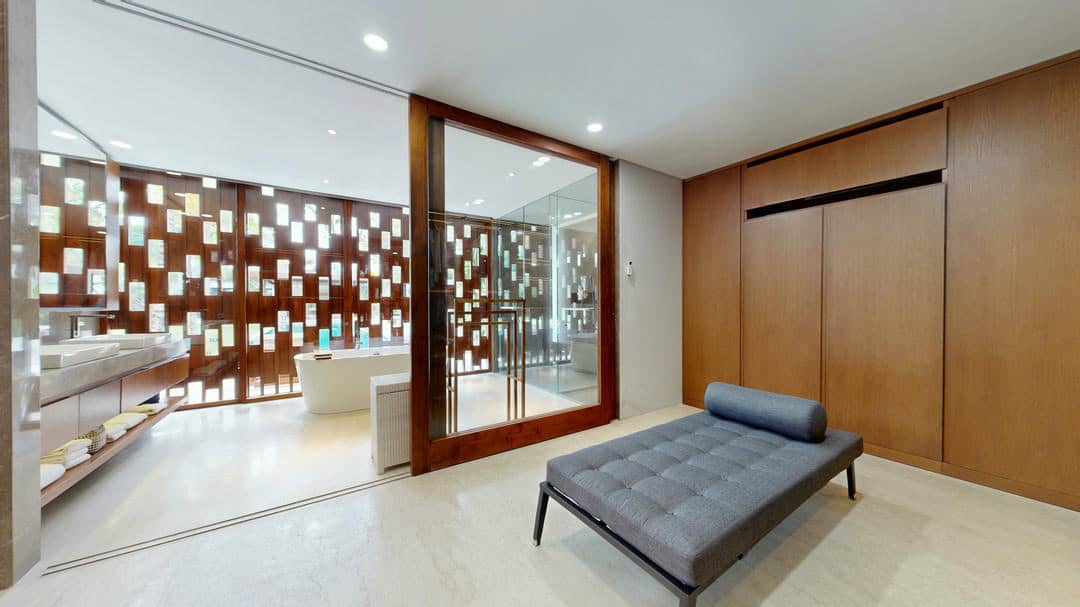 Modern bathroom with wooden accents and a lounge chair.