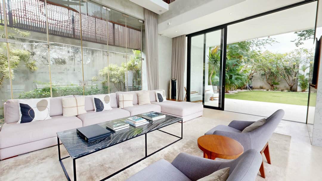Spacious living room with garden view and modern furniture.