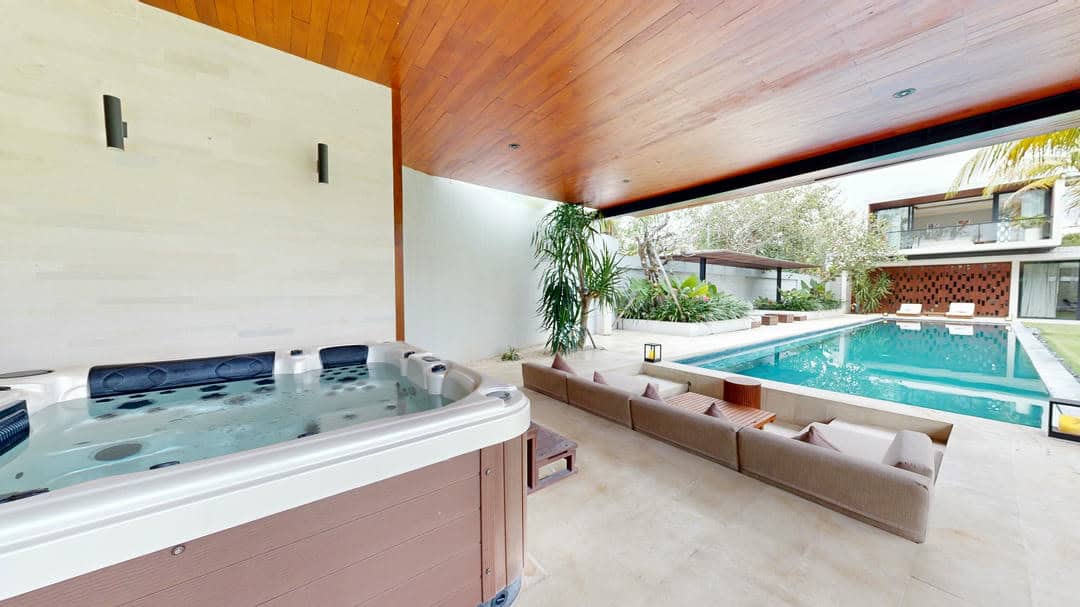 Luxurious outdoor pool and hot tub area with seating.
