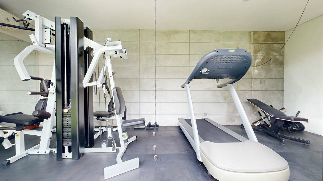 Home gym with treadmill and workout equipment.