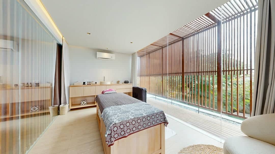 Modern spa room with massage table and decor.