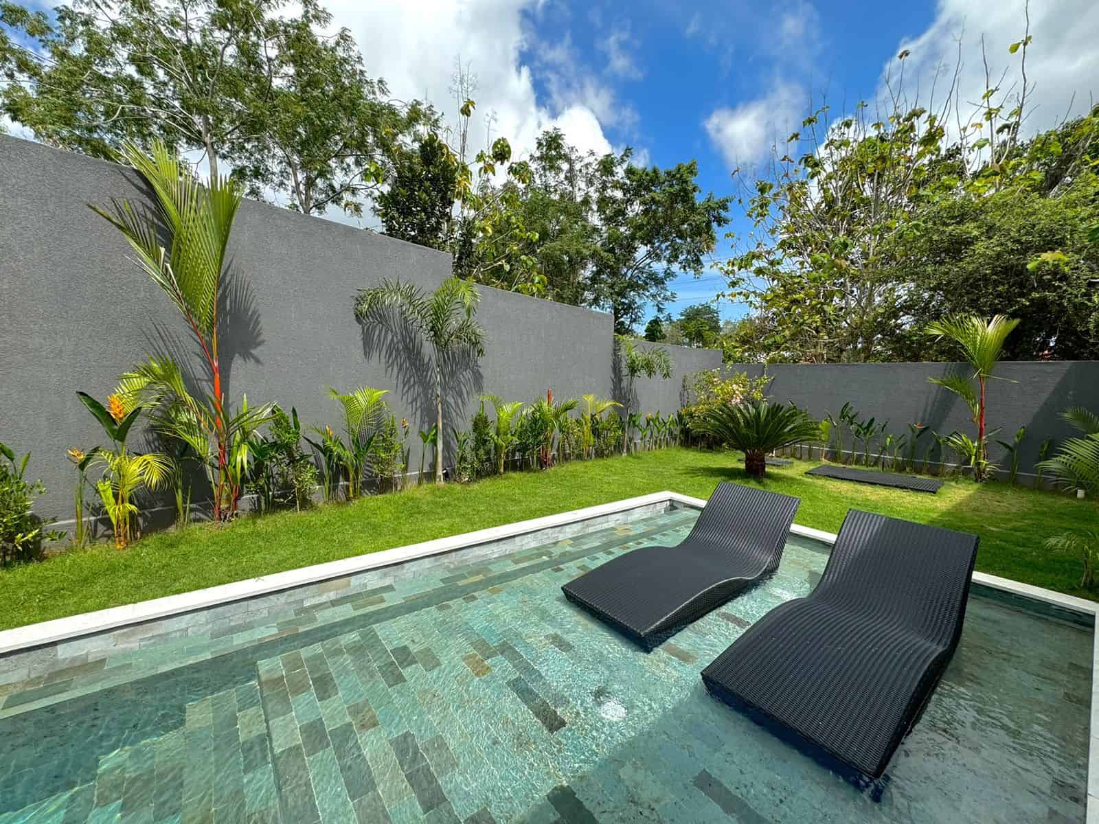 Tranquil backyard with pool and lounge chairs.