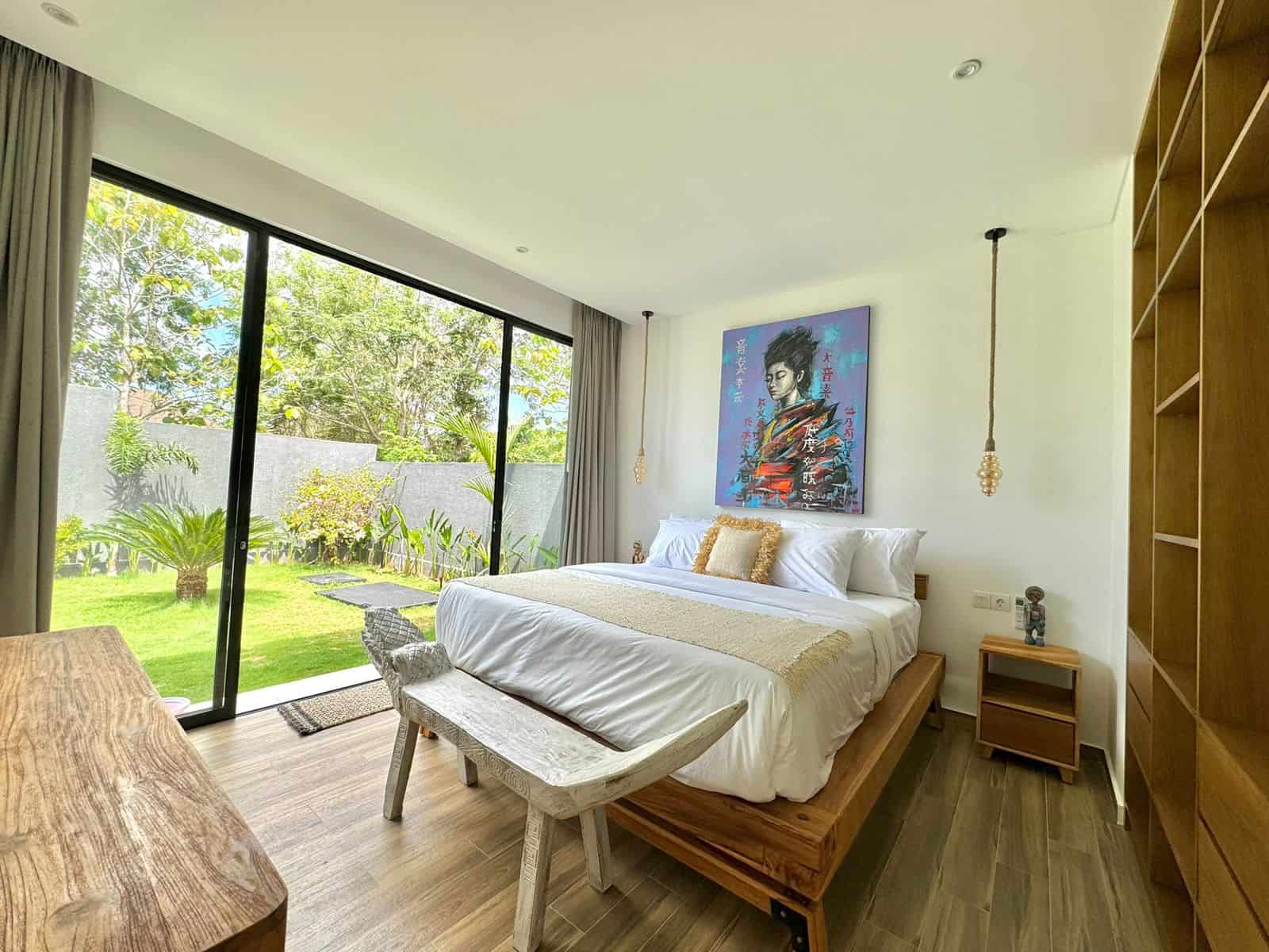 Modern bedroom with garden view and artwork.