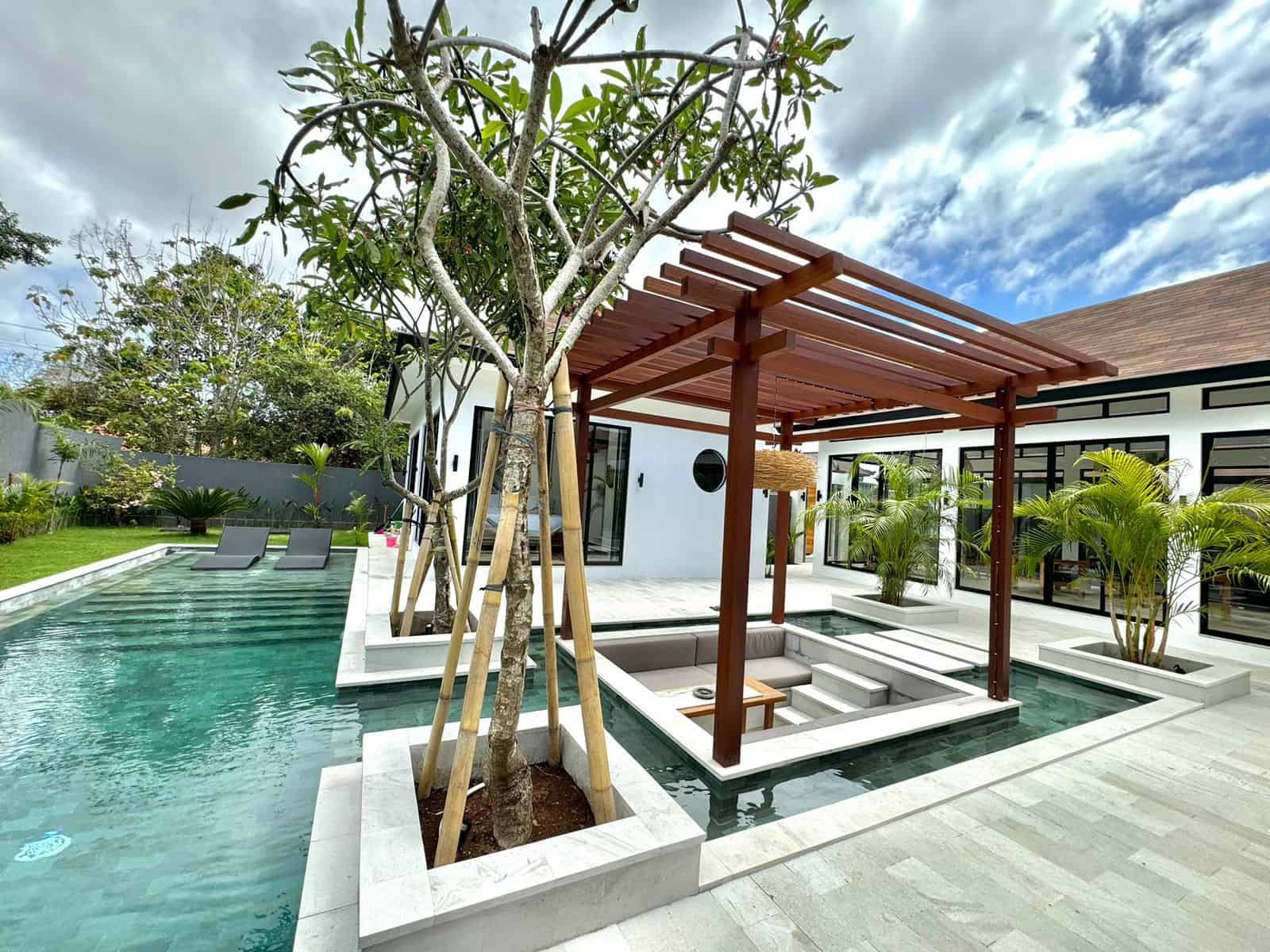 Modern villa with pool and pergola in garden.