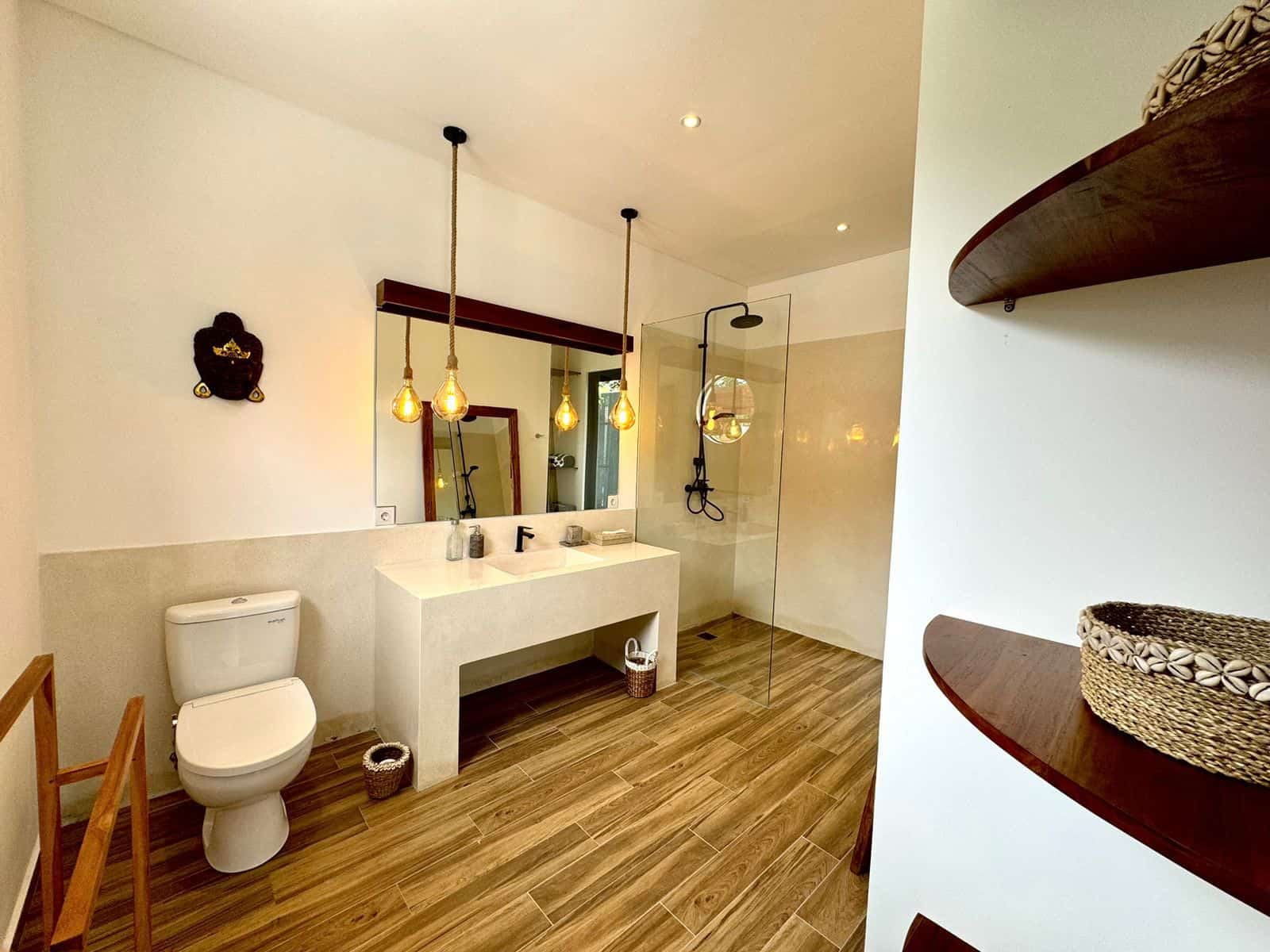 Modern bathroom with wooden floor and shower area.