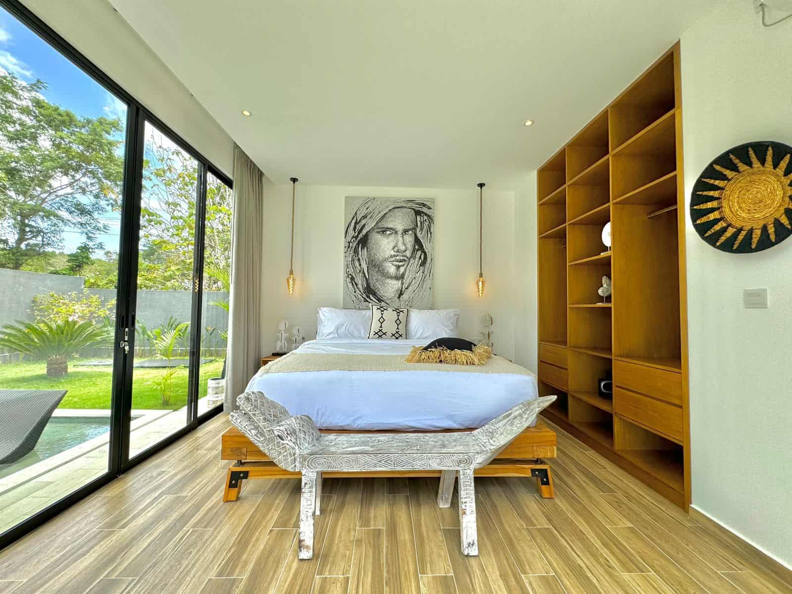 Modern bedroom with large window and garden view.