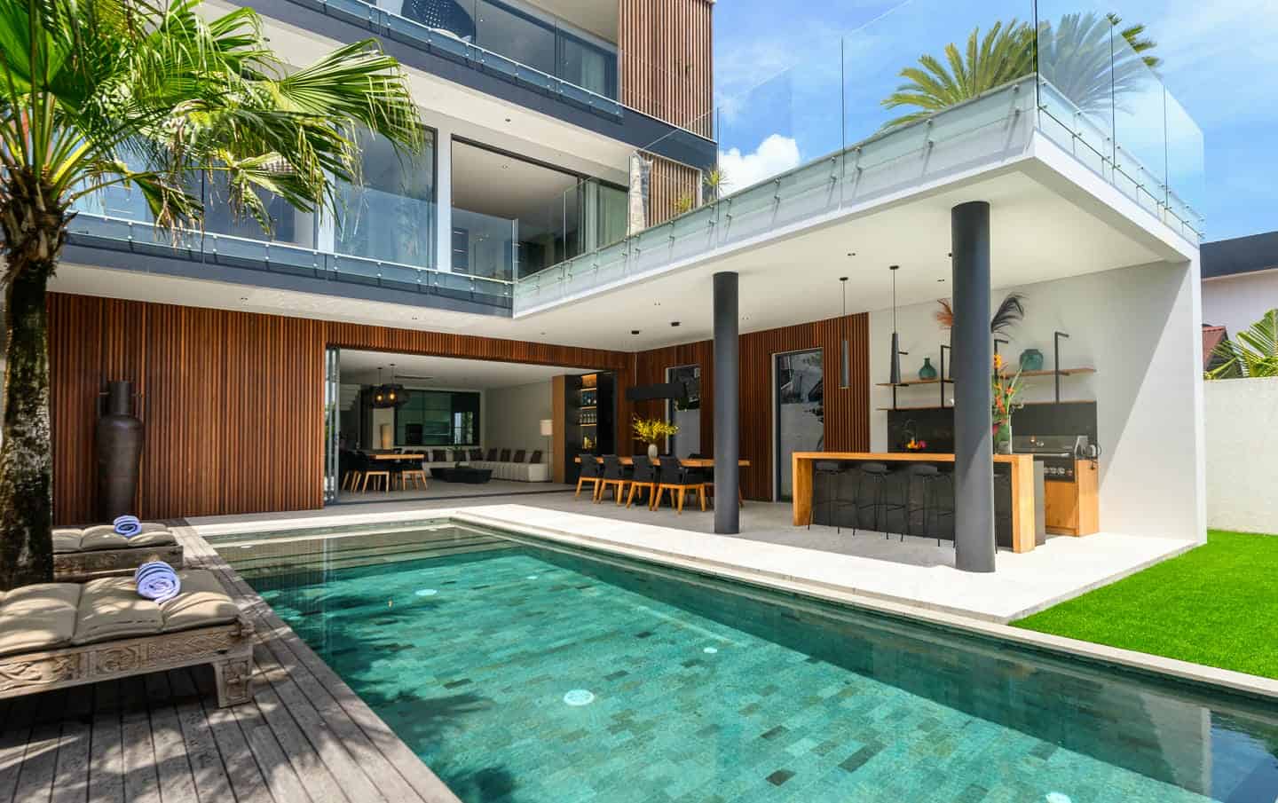Modern house with pool and outdoor dining area.