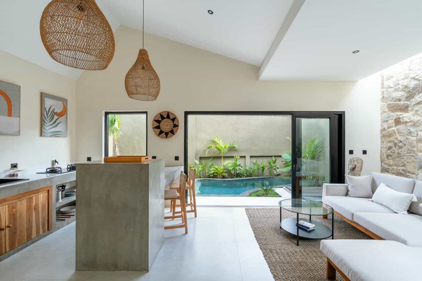 Modern living room and kitchen with pool view.