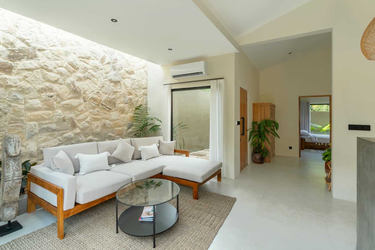 Modern living room with stone wall and plants.