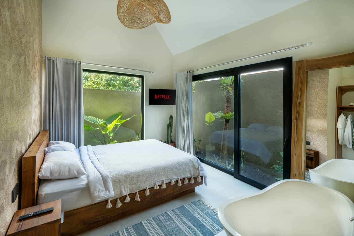 Modern bedroom with view and wall-mounted TV.