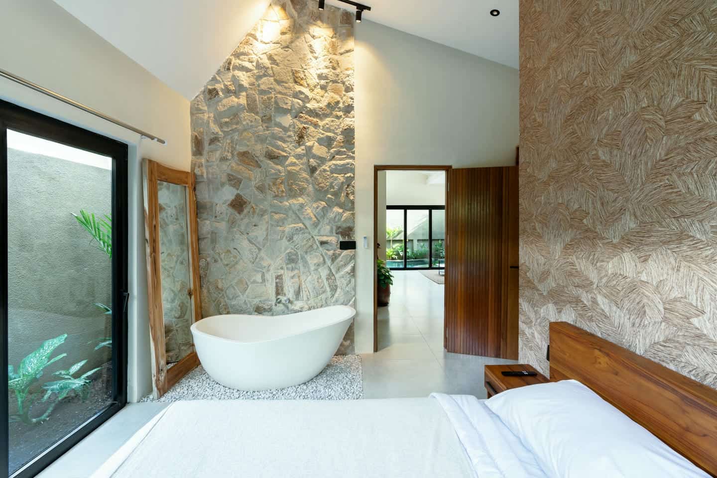 Modern bedroom with stone wall and bathtub
