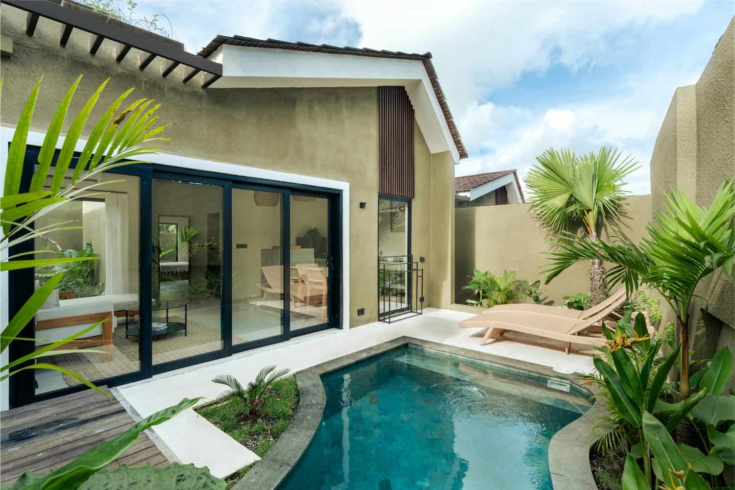 Modern villa courtyard with pool and tropical plants.