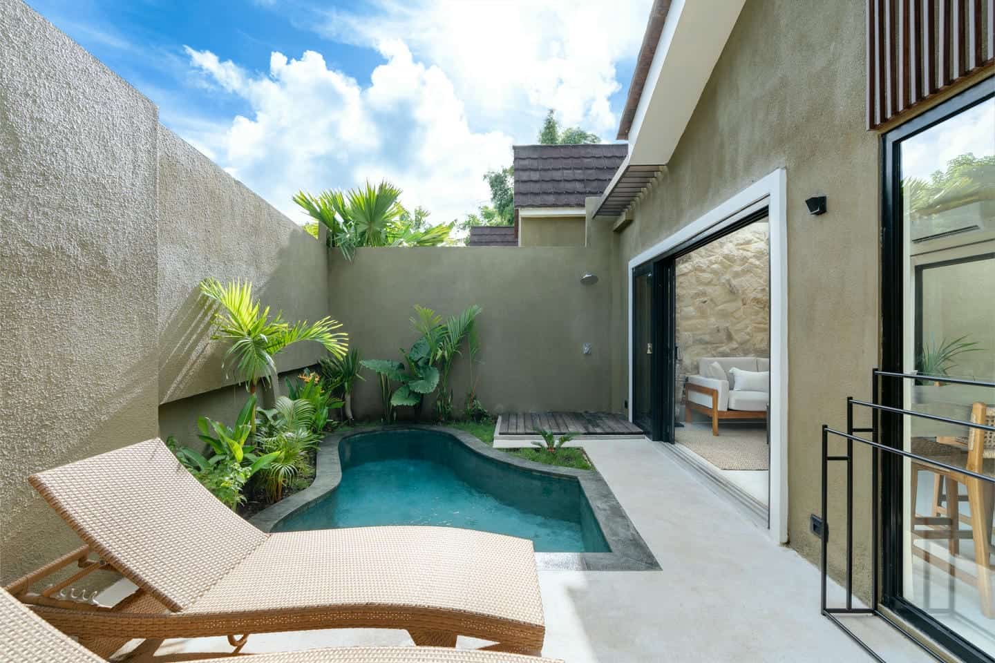 Small courtyard pool with lounge chairs and plants.