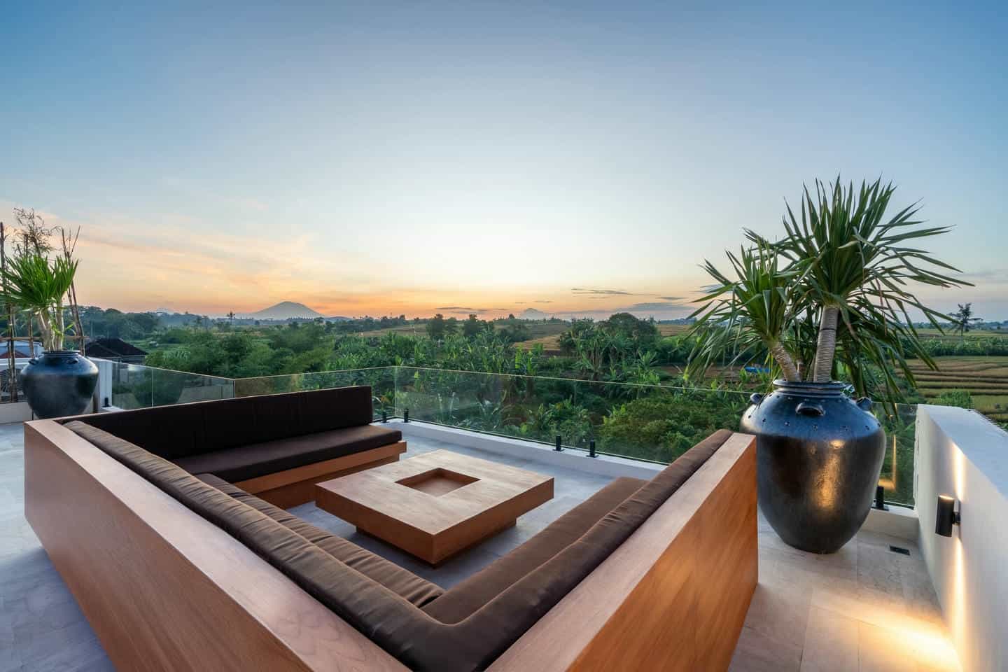 Outdoor terrace with view of lush landscape and sky.