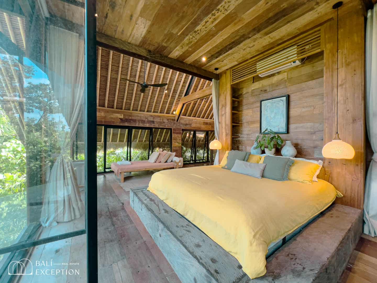 Spacious wooden bedroom with yellow bed linens.
