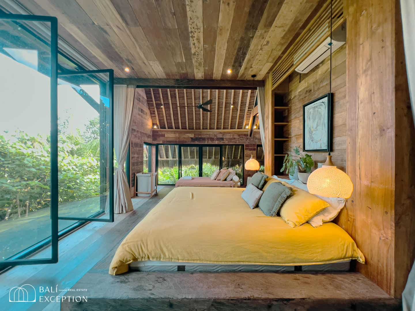 Luxury villa bedroom with wooden decor and garden view.