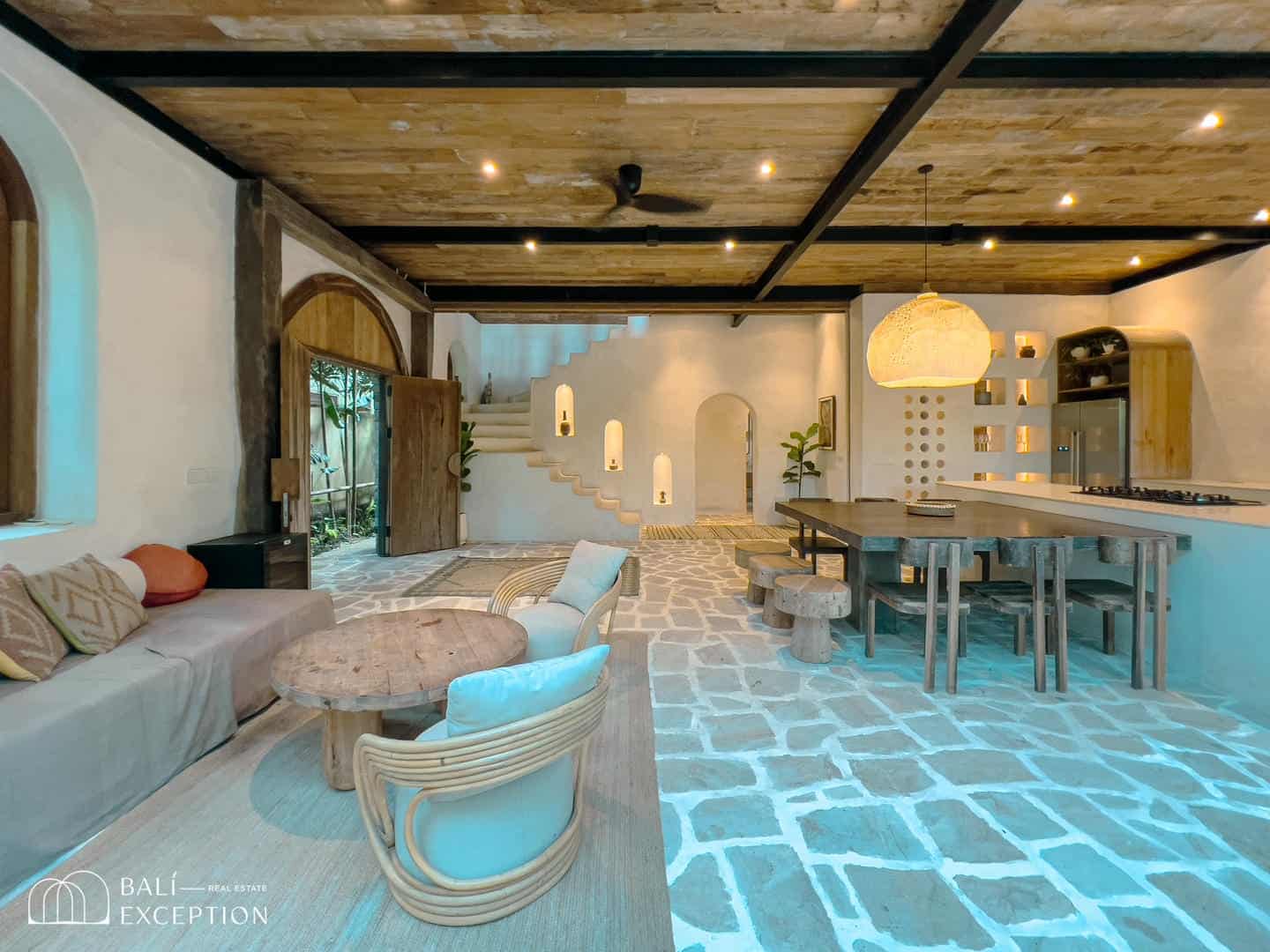 Rustic modern living room with wooden decor and stone floor.