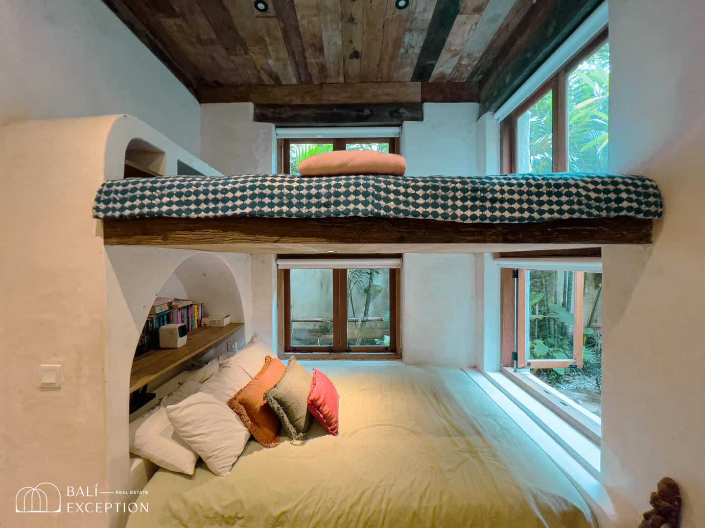 Cozy bedroom with loft bed and large windows.