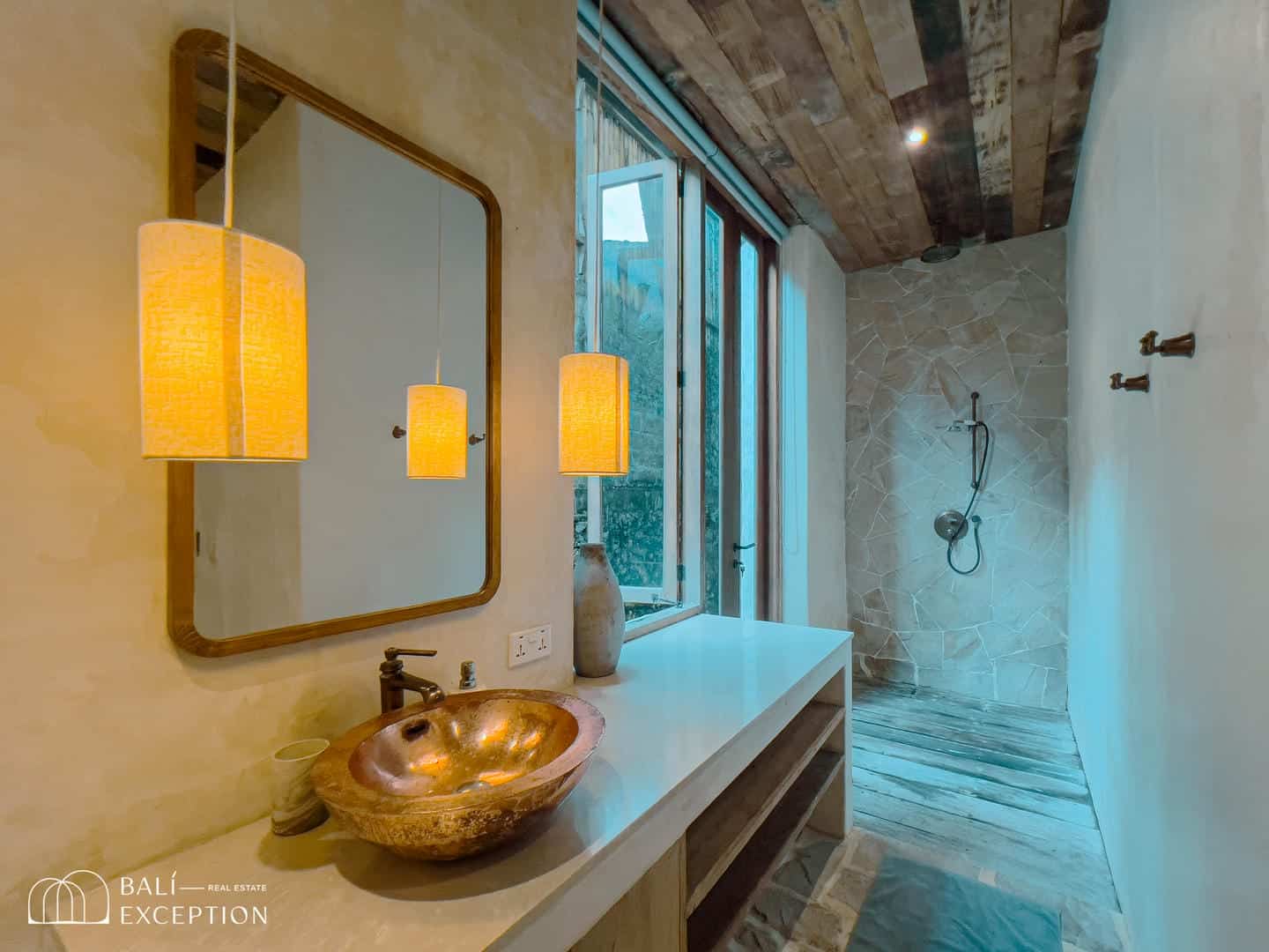 Rustic bathroom with stone sink and walk-in rain shower.