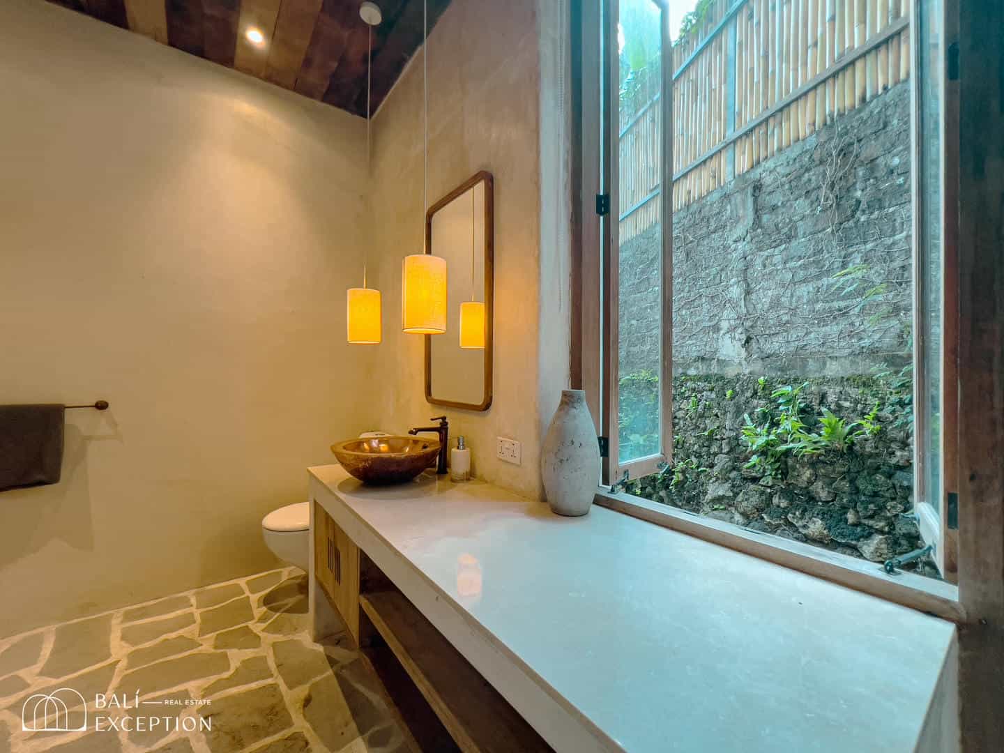 Modern bathroom with open window and stone sink.