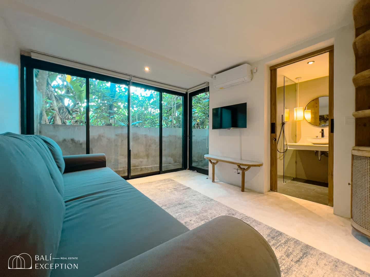 Modern living room with glass doors and bathroom view.