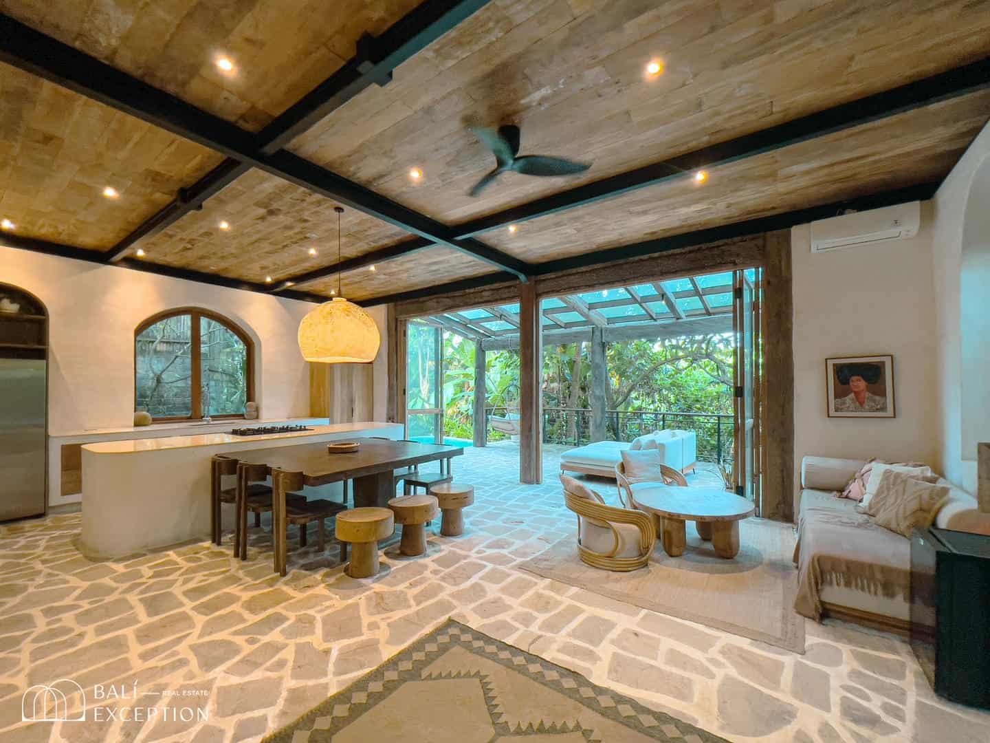 Modern rustic living room with open kitchen and veranda.