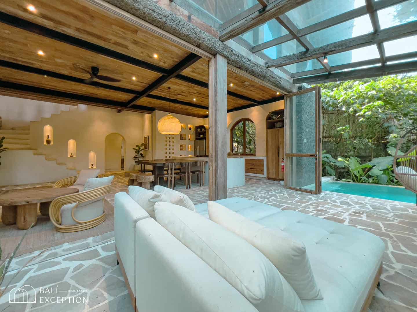 Modern open-air living room with pool view.