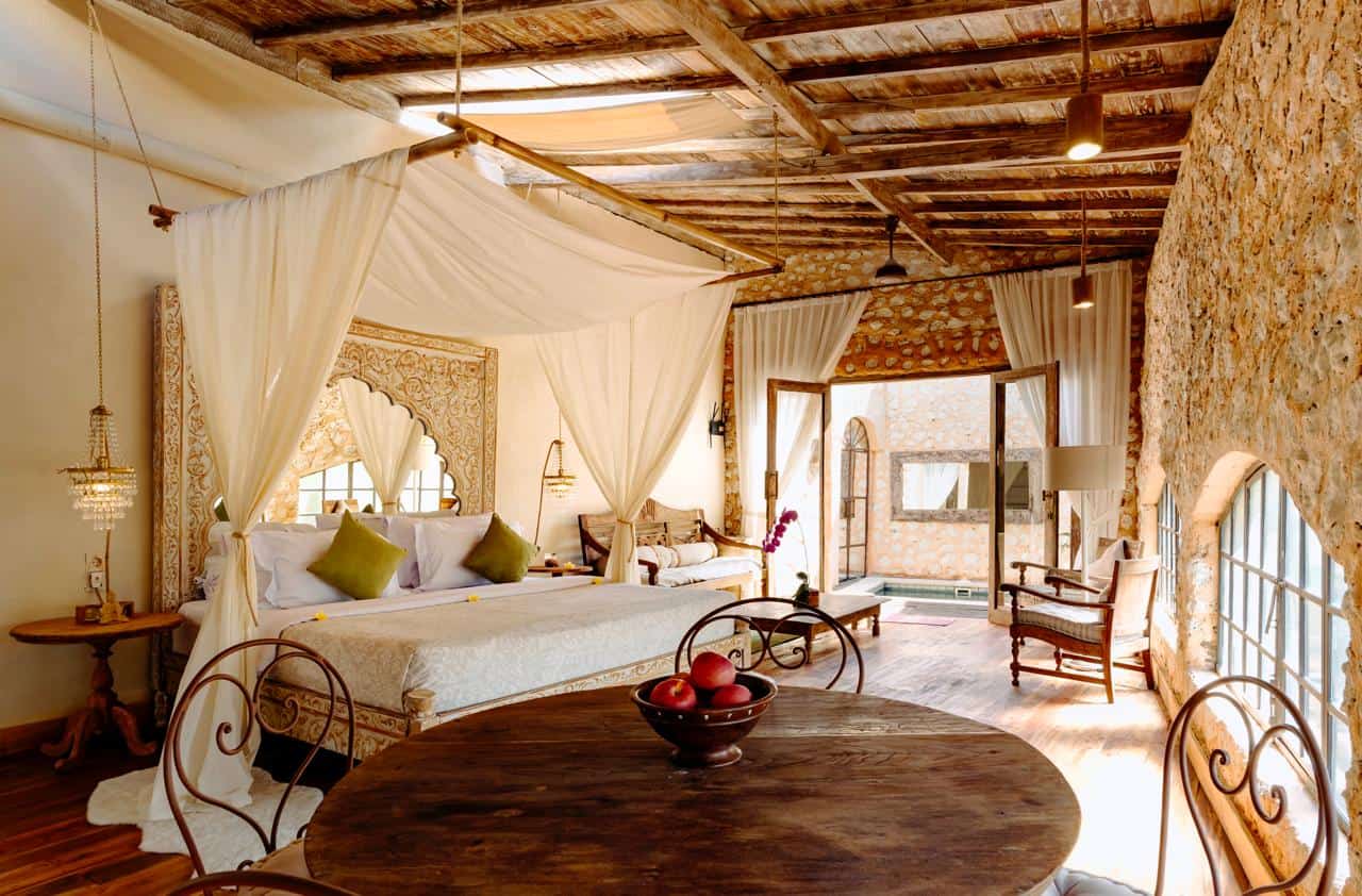 Luxury rustic bedroom with pool view and canopy bed.