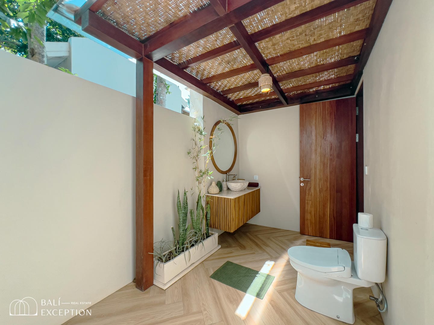 Stylish outdoor bathroom with wooden accents and greenery.