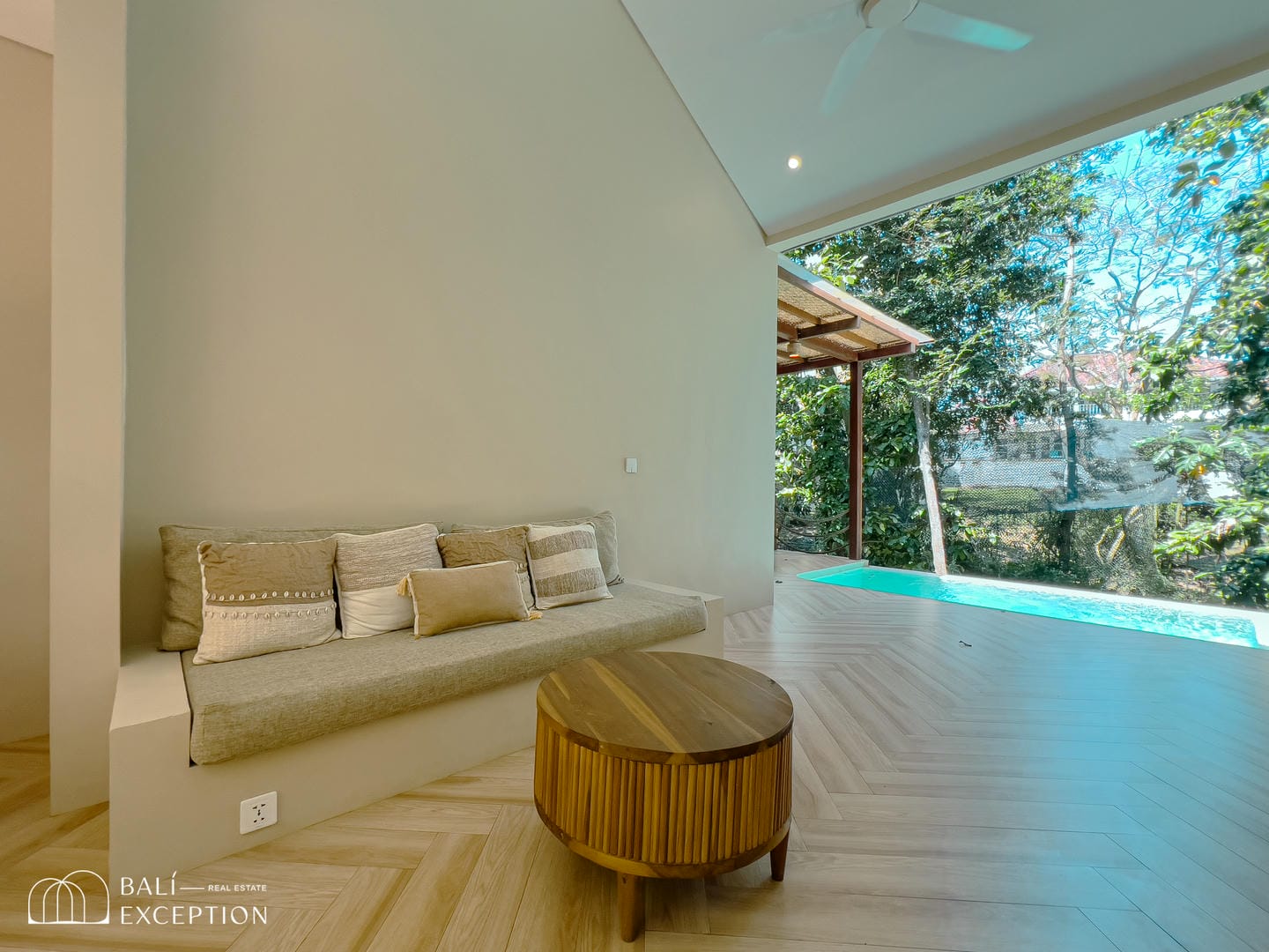 Minimalist living room with pool and garden view.