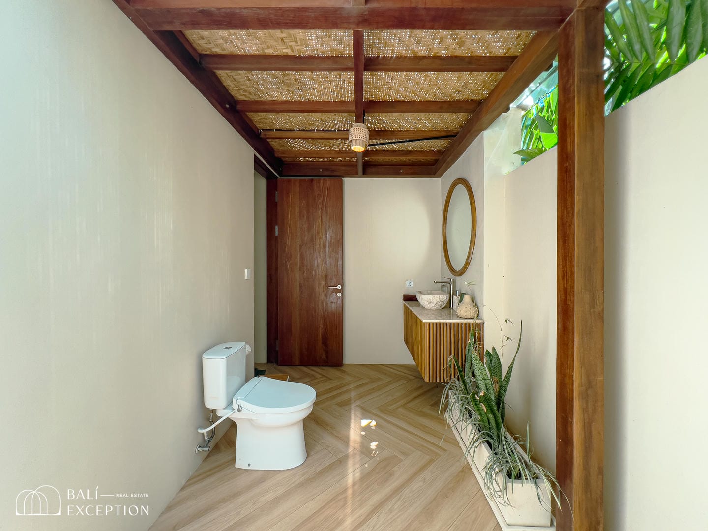 Bali-inspired bathroom with wooden elements and plants.