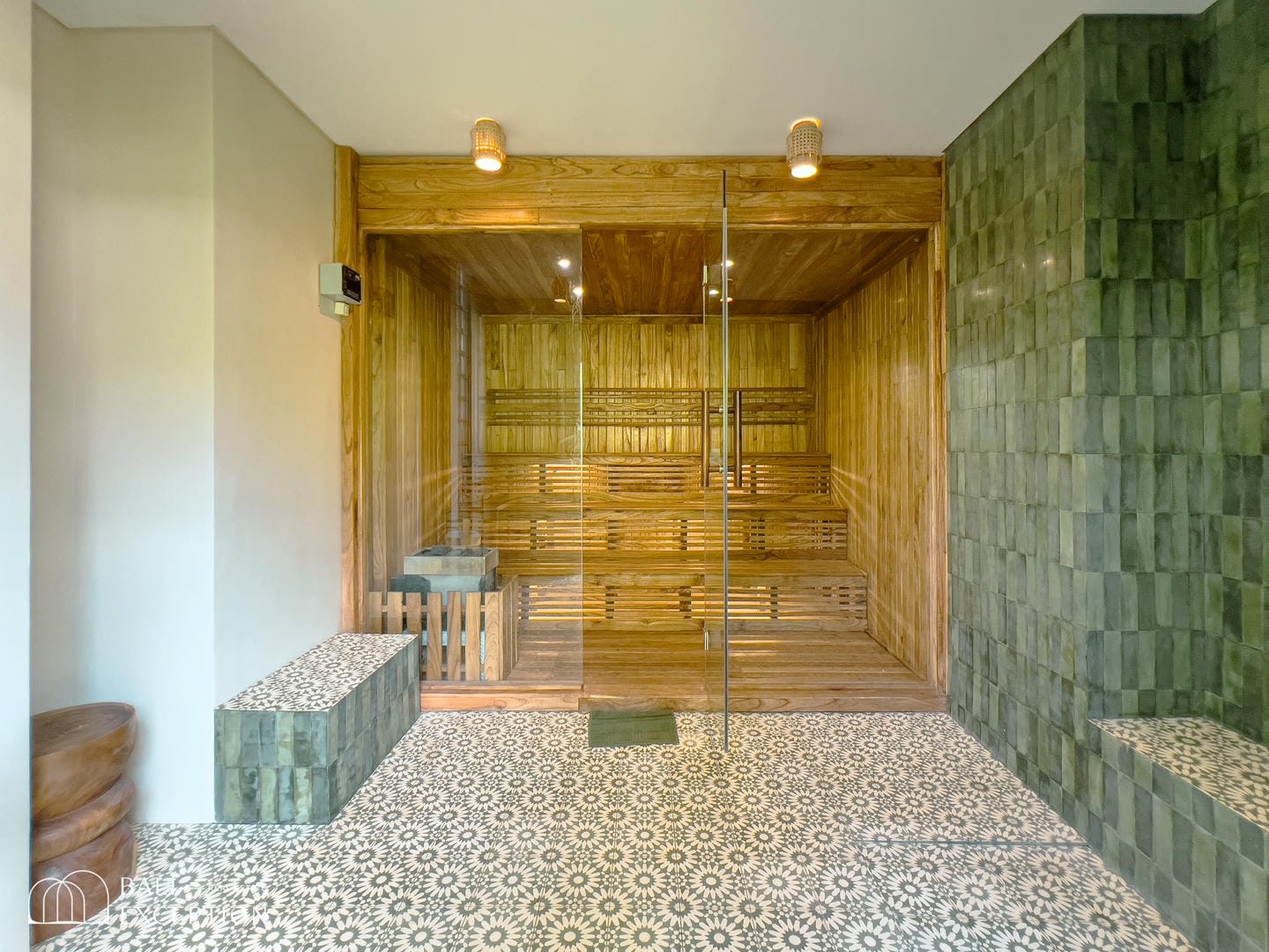 Modern wooden sauna with glass door and tile floor.