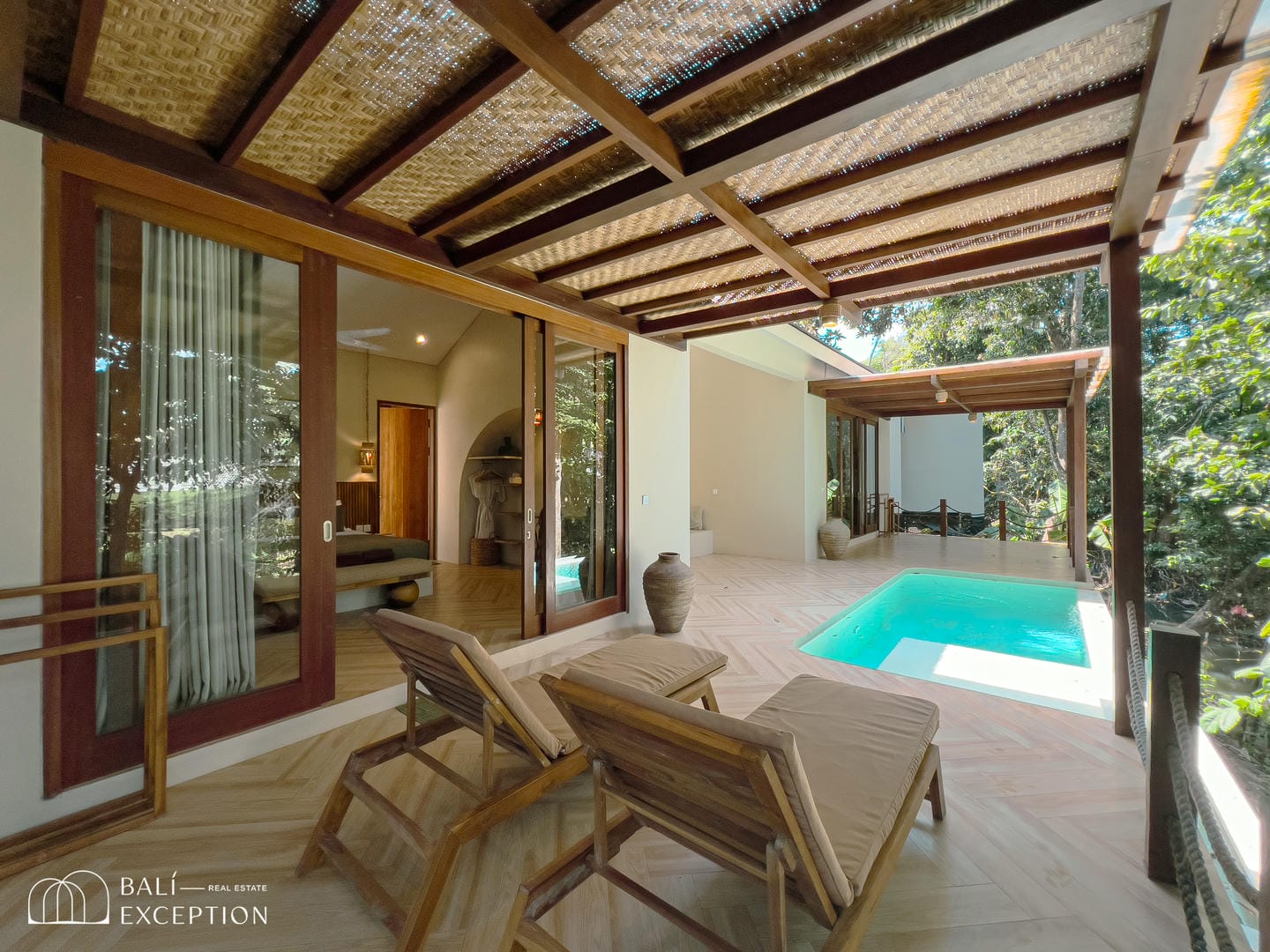 Modern villa patio with pool and lounge chairs.